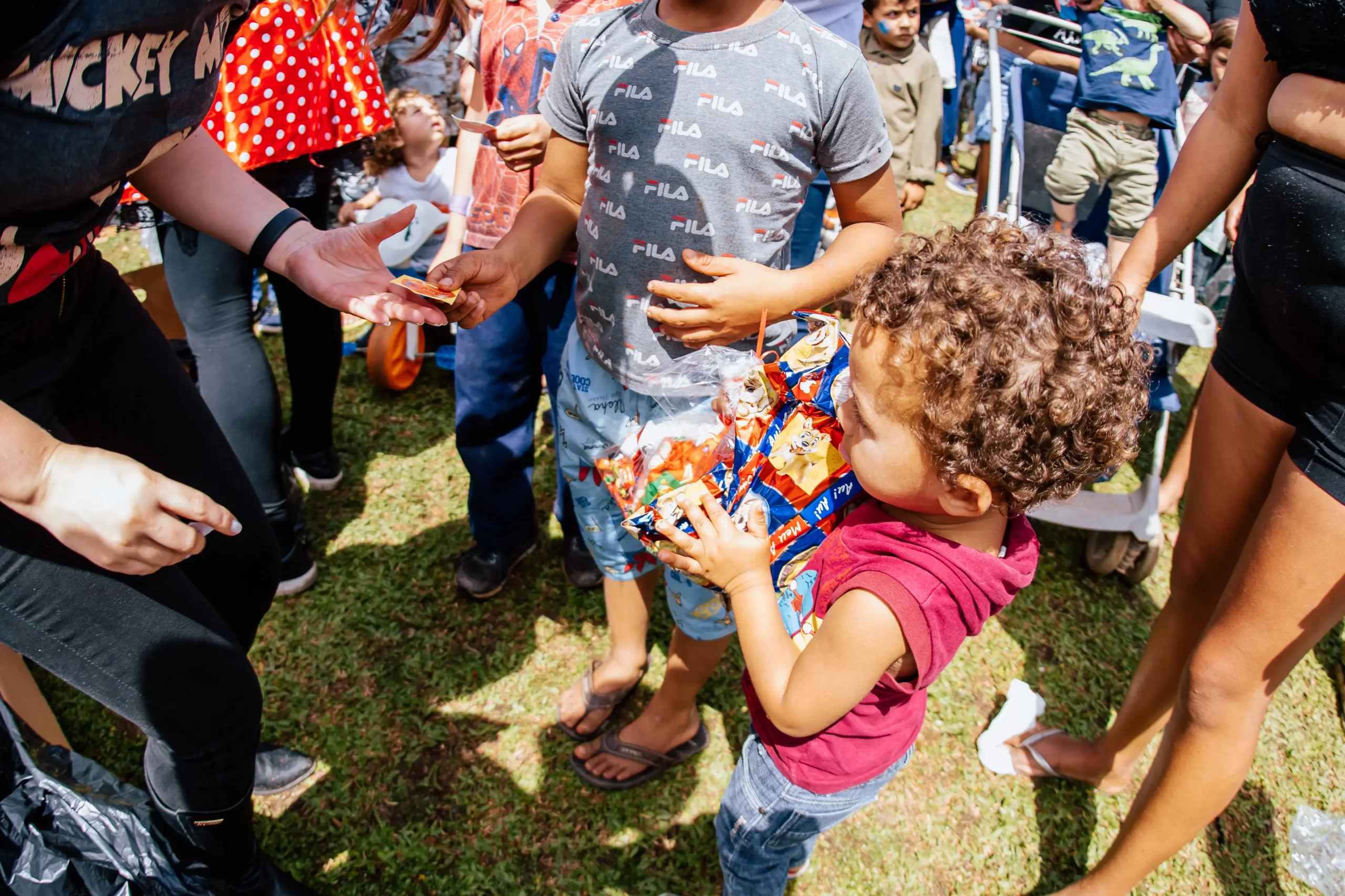 Voluntários e famílias reunidos durante uma ação do Rolê em Ação
